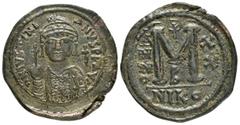 Byzantine Coins JUSTINIAN I.(527-565).Nicomedia.Follis. Obv : DN IVSTINIANVS PP AVG. Helmeted, cuirassed bust facing, holding cross on globe and shield with horseman motif, cross to right. Rev : Large