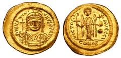 BYZANTINE EMPIRE. Justinian I, 527-565 AD. Gold Solidus (4.48 gm) of Constantinople. Helmeted bust facing with shield and globus cruciger / Angel standing with Christogram and globus cruciger. S.140. 